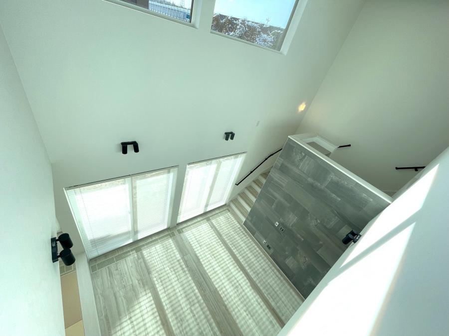 吹抜けから陽の光が差し込む開放感リビング